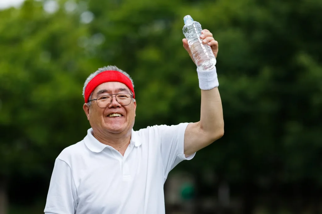 熱中症予防のため水分補給をする高齢者の男性