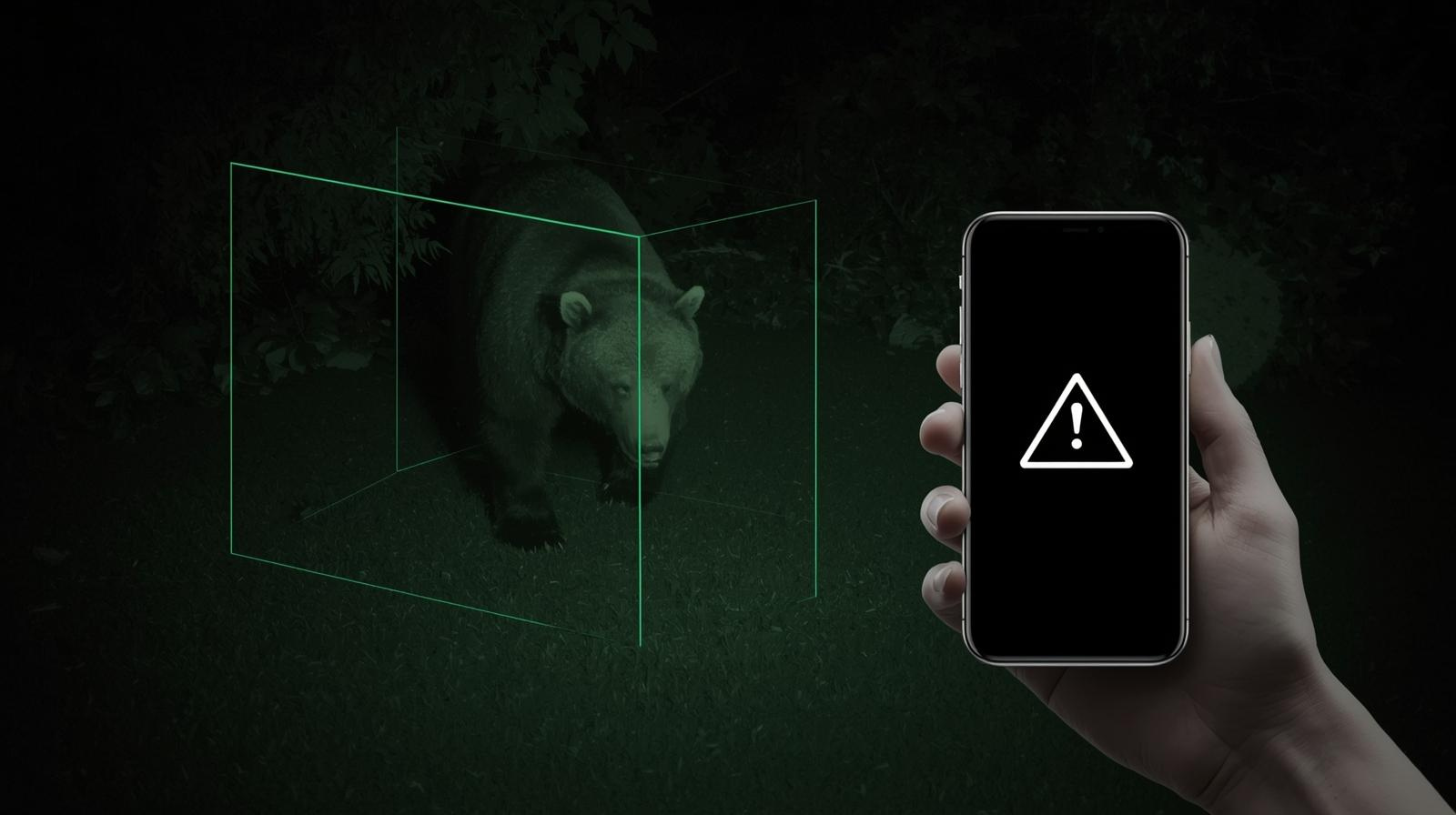 防犯カメラの暗視映像でクマを検知し、スマートフォンに通知が届いている様子